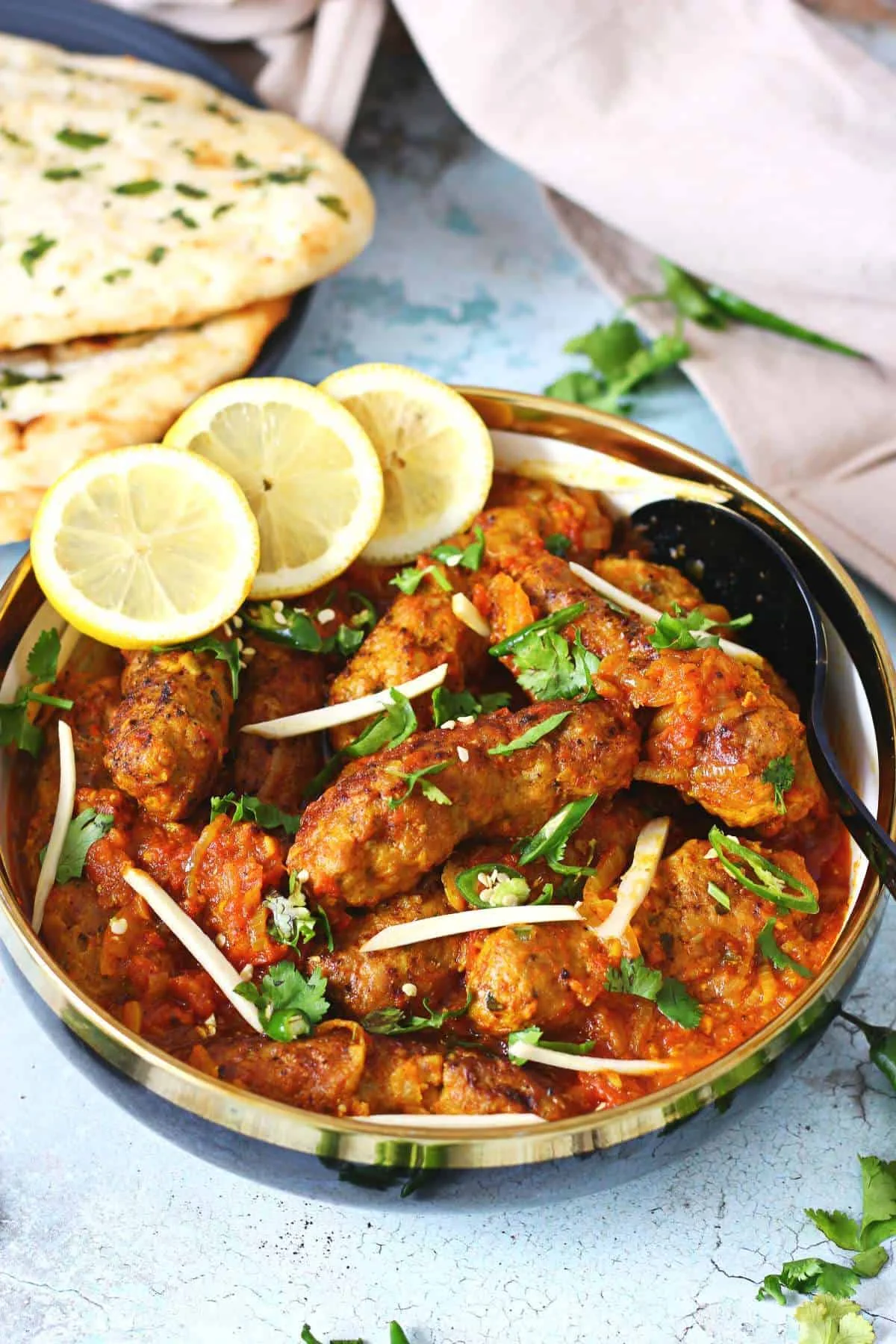 A richly spiced Indian curry finished with herbs, served in a shallow bowl